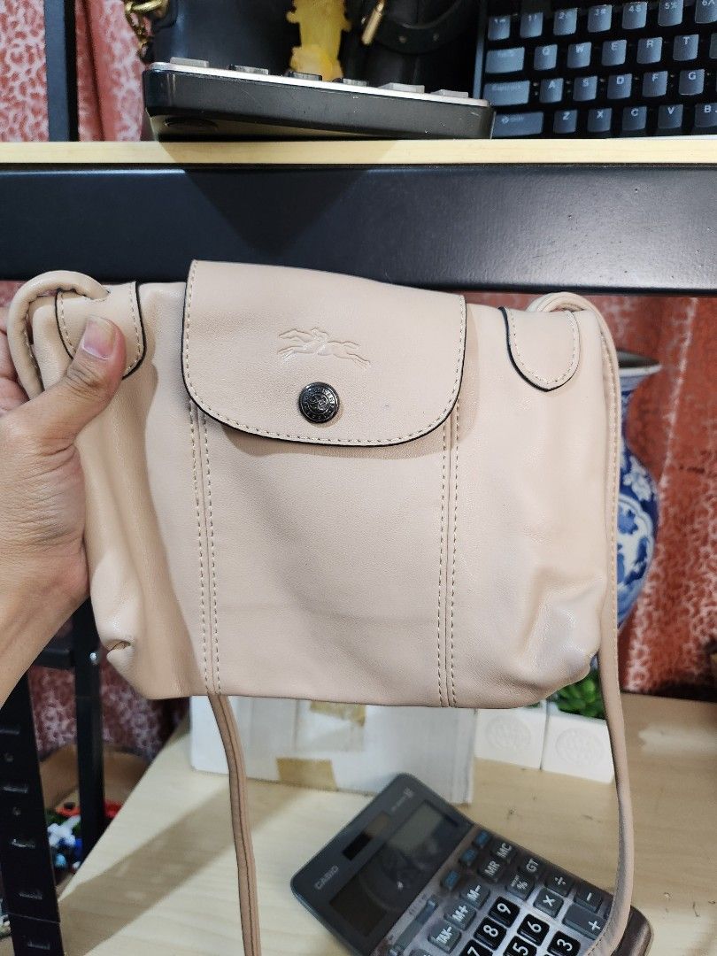 Longchamp Shoulder Bag (Category: Luxury Bags & Wallets) located in Baguio. Submitted by alonasteph (Listing ID 1402113973, Image 3). Description: - Longchamp shoulder bag - Color: Light beige - Closure: Flap with snap button and zip - Shoulder strap included - Interior lining with repeating pattern - Small logo detail.