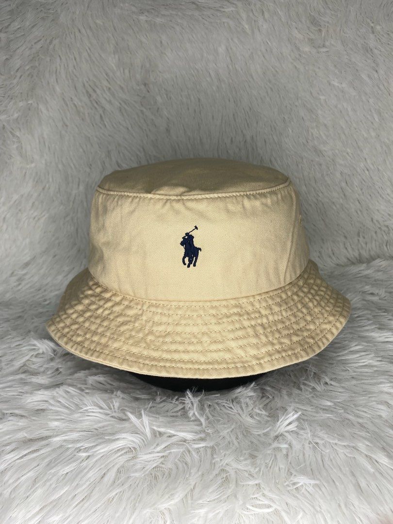 Polo Ralph Lauren Bucket Hat (Category: Caps & Hats) located in Batangas. Submitted by lifehitz.ph (Listing ID 1402255810, Image 1). Description: Polo Ralph Lauren bucket hat is a classic accessory. It features the iconic polo player logo. The hat is a neutral beige color. The interior has a tag with the Polo Ralph Lauren branding..