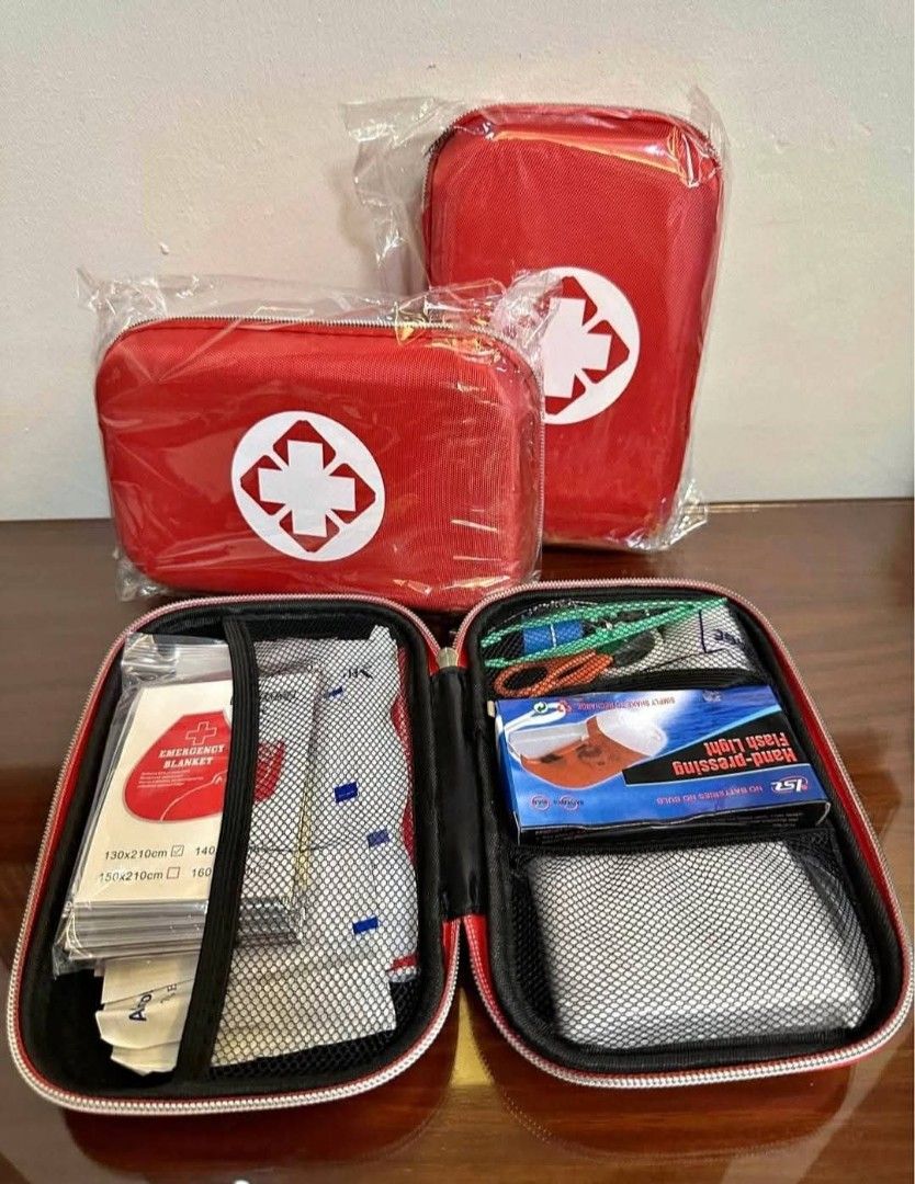 Red First Aid Kit (Category: Medical Supplies & Tools) located in Mandaluyong City. Submitted by shopmla (Listing ID 1402194499, Image 3). Description: Compact first aid kit in a red hard case. Includes essential items like an emergency blanket, alcohol pads, gauze swabs, plastic bandages, and a flashlight. Also contains a whistle, scissors, and tweezers. The case measures approximately 21cm x 13cm x 5.5cm. Perfect for home, travel, or outdoor ac