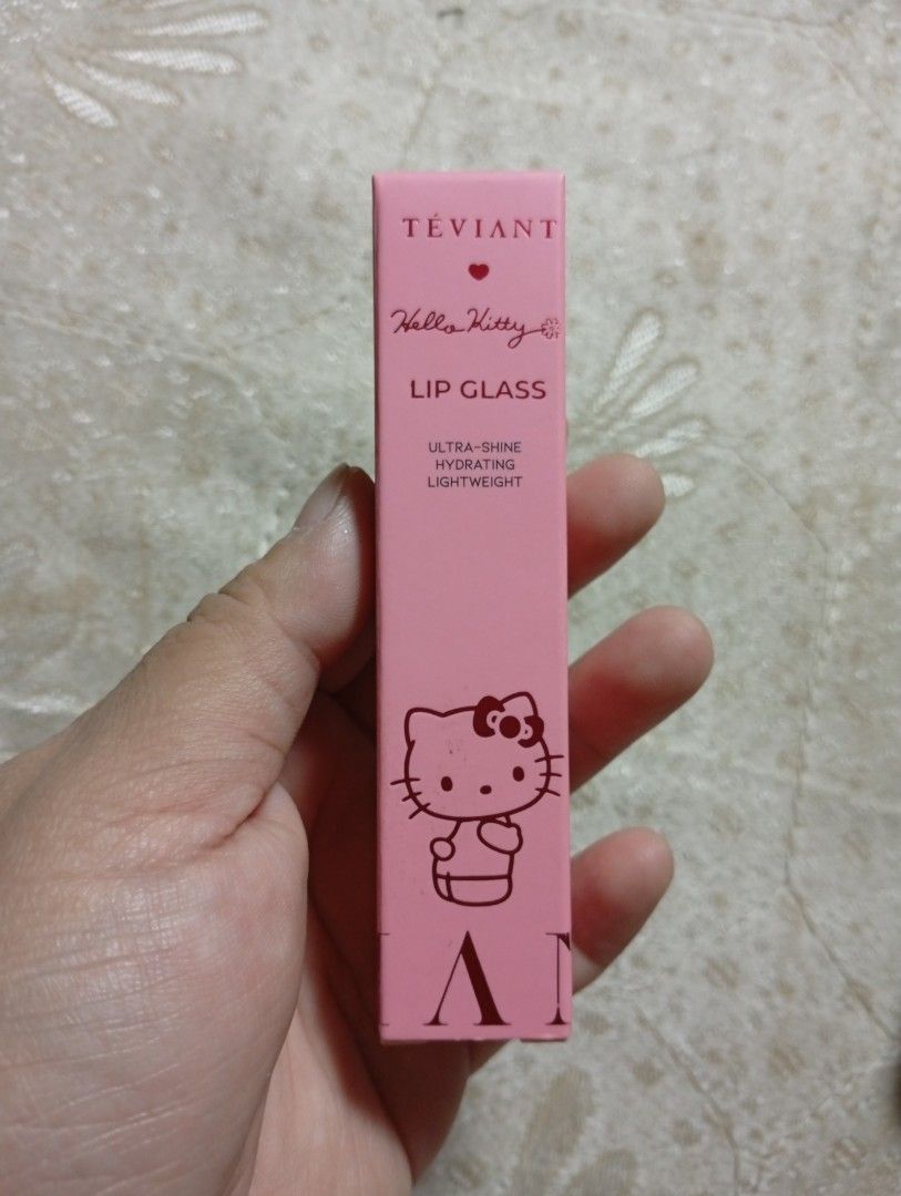 Teviant Hello Kitty Lip Glass (Category: Makeup) located in Quezon City. Submitted by janjanrie_2923 (Listing ID 1402146438, Image 2). Description: Teviant Kitty Lip Glass is a hydrating and lightweight lip gloss. It features an ultra-shine finish. The packaging includes a pink box with a Kitty design.