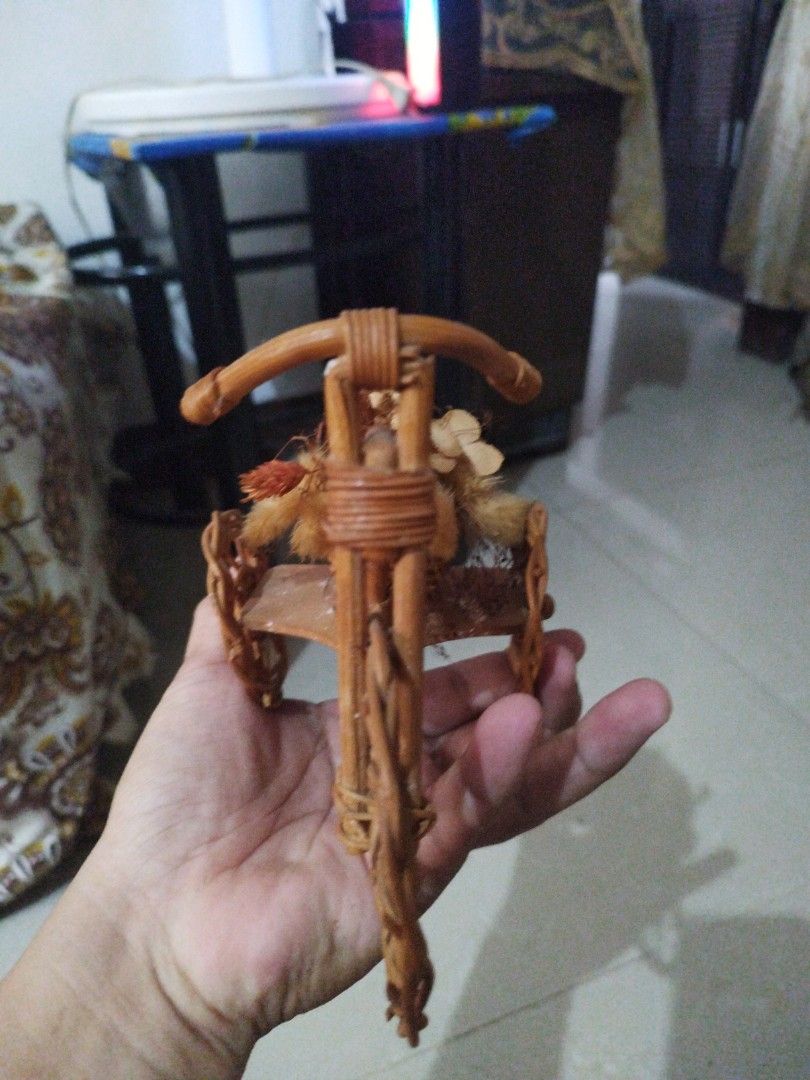 Wicker Tricycle with Floral Basket (Category: Motorbikes for Sale) located in Abucay. Submitted by jflshoppe1989 (Listing ID 1402285950, Image 2). Description: Decorative tricycle is made of woven wicker. It features a small basket filled with dried flowers and decorative elements. The tricycle has three wheels and a handlebar. It is a charming piece that can be used as a decorative item or a unique display piece..