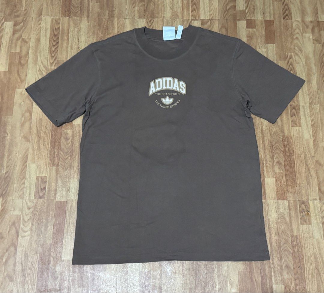 Adidas T-shirt (Front and Back Print) (Category: Tshirts & Polo Shirts ) located in Cainta. Submitted by drmp_9693 (Listing ID 1402301626, Image 2). Description: - Brown Adidas t-shirt - Adidas logo on front and back - Features "The Brand With The Three Stripes" text - Crew neck - Short sleeves - Solid brown color - From US.