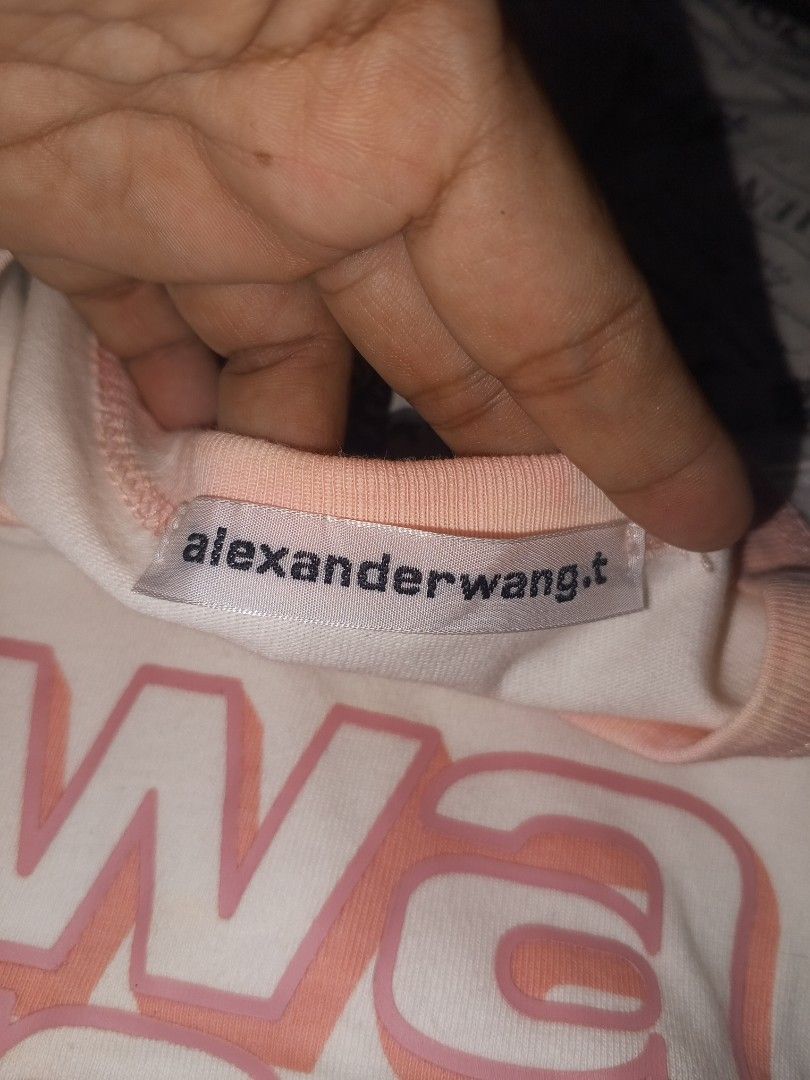 Alexander Wang Wang Tee (Category: Luxury Apparel) located in Magalang. Submitted by zeiansoria64090 (Listing ID 1402355002, Image 2). Description: - Alexander Wang t-shirt - Size: L best fit Med - Color: White with pink collar - Design: "wang" print - Made in Turkey - Material: - Body: 100% cotton - Collar: 100% polyester - Condition: Visible stains -issue discoloration and yellowish.