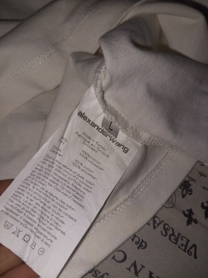 Alexander Wang Wang Tee (Category: Luxury Apparel) located in Magalang. Submitted by zeiansoria64090 (Listing ID 1402355002, Image 3). Description: - Alexander Wang t-shirt - Size: L best fit Med - Color: White with pink collar - Design: "wang" print - Made in Turkey - Material: - Body: 100% cotton - Collar: 100% polyester - Condition: Visible stains -issue discoloration and yellowish.