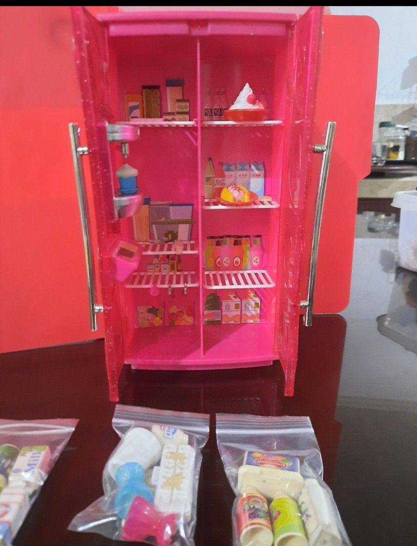Barbie Pink Refrigerator with Accessories (Category: Kids Toys) located in Quezon City. Submitted by bonasheryl63965 (Listing ID 1402324998, Image 1). Description: - Pink dollhouse refrigerator - Includes miniature food items: milk cartons, juice bottles, cake - Features shelves and doors - Accessories packaged in clear bags - Ideal for dollhouse play includes 1 doll.