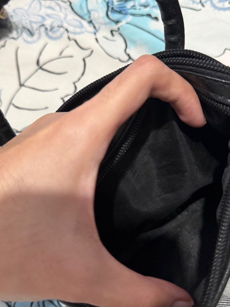 Black Mini / micro Handbag (Category: Luxury Bags & Wallets) located in Batangas. Submitted by _khaori (Listing ID 1402472896, Image 2). Description: - Small black handbag - Top handle - Zippered main compartment - Interior zippered pocket - Decorative stitched design - Silver-toned clasp - Black fabric lining - Compact size - Ideal for carrying essentials.