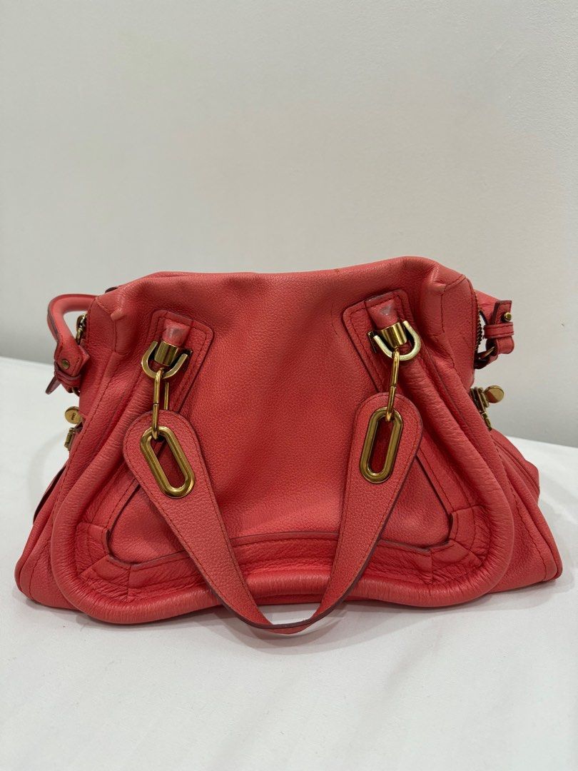 Chloe Paraty Handbag (Category: Luxury Bags & Wallets) located in Taguig. Submitted by getintomycloset (Listing ID 1402412164, Image 3). Description: - Chloe Paraty handbag - Coral color - Includes top handle and shoulder strap - Gold-toned hardware - Secure zipper closure - Textured leather finish - Classic, structured design.