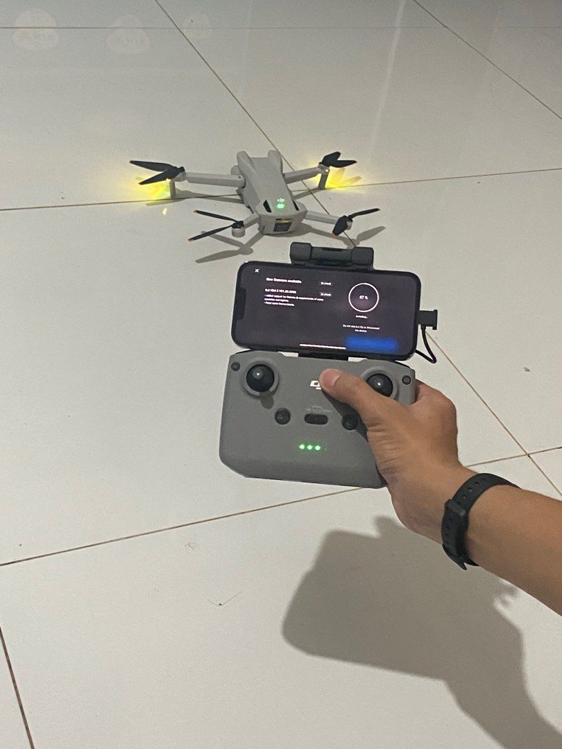 DJI Mini 3 Drone [FOR RENT] (Category: Drones) located in Manila. Submitted by purelion-536c (Listing ID 1402342493, Image 2). Description: FOR RENT DJI Mini 3 drone with remote controller. The drone is white and gray. The remote controller has a phone holder. The drone is shown in use, with the controller displaying the live feed. The drone has its propellers attached and is ready to fly. The drone is shown outdoors and indoors. Equipment Rented