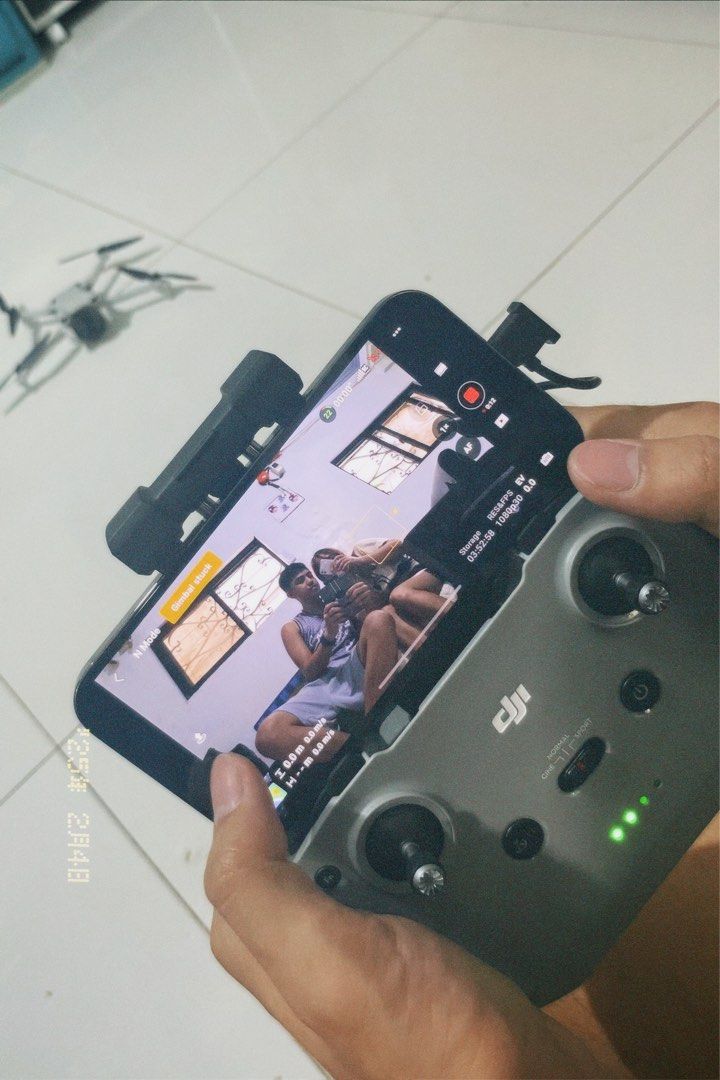 DJI Mini 3 Drone [FOR RENT] (Category: Drones) located in Manila. Submitted by purelion-536c (Listing ID 1402342493, Image 3). Description: FOR RENT DJI Mini 3 drone with remote controller. The drone is white and gray. The remote controller has a phone holder. The drone is shown in use, with the controller displaying the live feed. The drone has its propellers attached and is ready to fly. The drone is shown outdoors and indoors. Equipment Rented