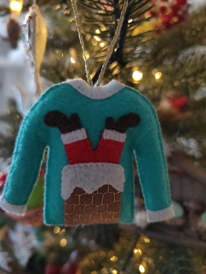 Handmade Ugly Sweater Christmas Ornament (Category: Other Home Decor) located in Mandaluyong City. Submitted by patchandpast (Listing ID 1402366882, Image 1). Description: Adorable Christmas ornament is shaped like a teal sweater with a chimney and Santa's legs sticking out. It's handmade from felt and has a gold string for hanging. Perfect for adding a festive touch to your Christmas tree or as a unique gift. The ornament is lightweight and easy