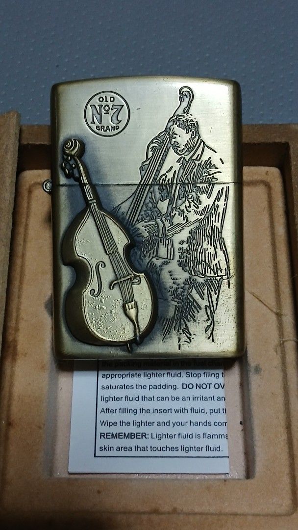 1996 Star JazzJack Daniel's Zippo style Lighter (Category: Vintage Collectibles) located in Quezon City. Submitted by mrs.maria (Listing ID 1402427701, Image 2). Description: "1996 Star Jazz" Jack Daniel's Zippo style lighter features a unique design with a musical instrument motif. It comes in its original box, which also features the Jack Daniel's branding. The lighter has an antique brass finish. The box includes a small instruction card. The 