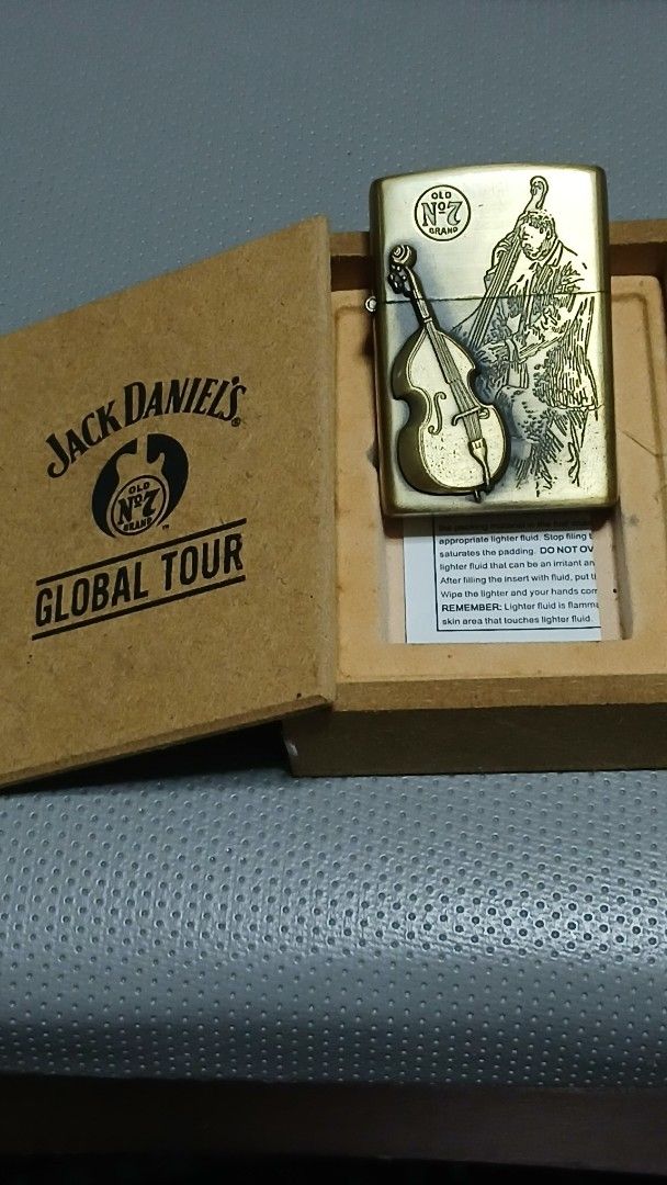 1996 Star JazzJack Daniel's Zippo style Lighter (Category: Vintage Collectibles) located in Quezon City. Submitted by mrs.maria (Listing ID 1402427701, Image 1). Description: "1996 Star Jazz" Jack Daniel's Zippo style lighter features a unique design with a musical instrument motif. It comes in its original box, which also features the Jack Daniel's branding. The lighter has an antique brass finish. The box includes a small instruction card. The 