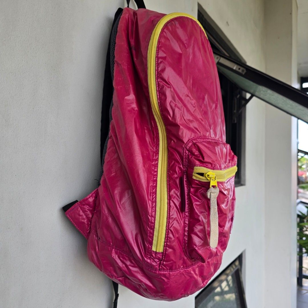 Outdoor Products Packable Backpack (Category: Backpacks) located in Macabebe. Submitted by pampanga_chic (Listing ID 1402316097, Image 3). Description: vibrant pink backpack with yellow zippers. It features a main compartment and a front pocket, both with zippers. The backpack has adjustable shoulder straps and a mesh back panel for comfort. It also has a small interior pocket. The backpack is packable and can be folded for easy storage. please r