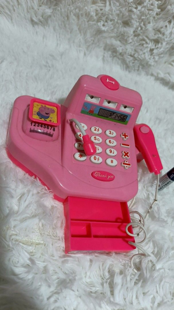 Pink Toy Cash Register (Category: Kids Toys) located in Marikina City. Submitted by andreah_16 (Listing ID 1402289444, Image 3). Description: - Pink toy cash register - Features a calculator, scanner, and cash drawer - Includes a toy microphone - Small display screen - Adorned with a Peppa Pig sticker - Comes with a battery.