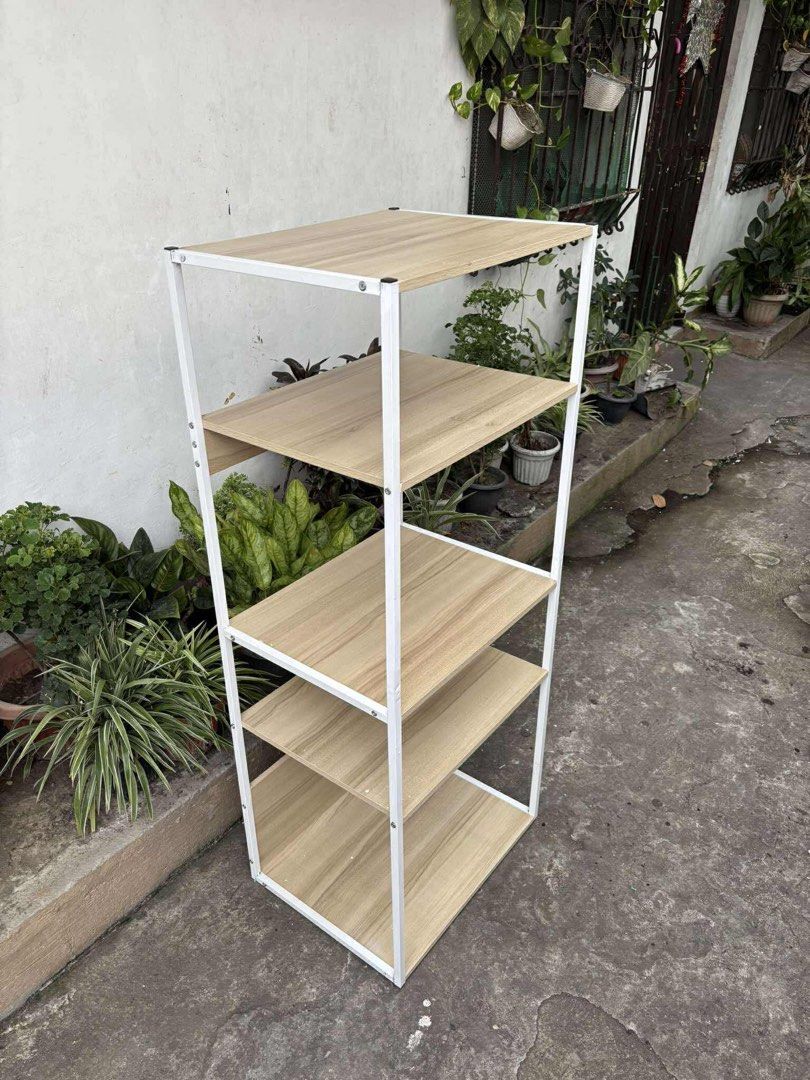 4-Tier Wooden Shelf with White Frame (Category: Shelves, Cabinets & Racks) located in Cavite. Submitted by faelejarde (Listing ID 1402637838, Image 2). Description: -51*40*128cm 4-tier shelf features a sturdy white metal frame and wooden shelves. It's perfect for organizing books, plants, or other items. The shelves offer ample storage space and the design is simple and modern. It's a great addition to any living room, bedroom, or office space..