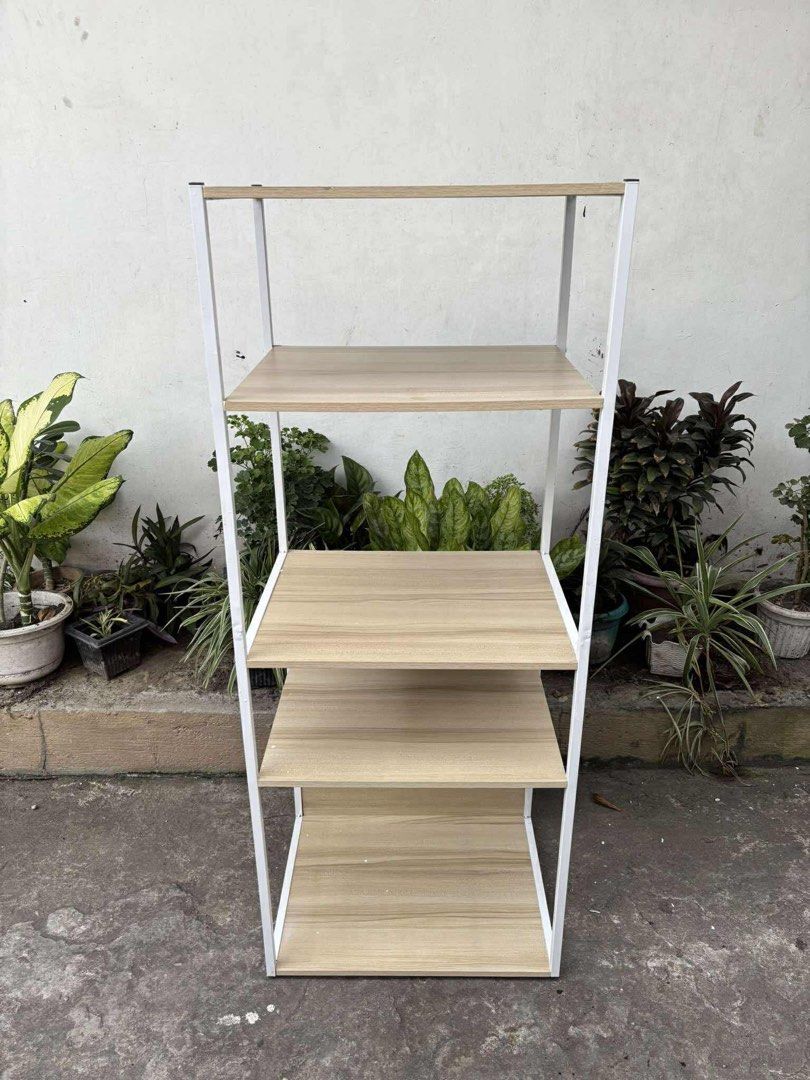 4-Tier Wooden Shelf with White Frame (Category: Shelves, Cabinets & Racks) located in Cavite. Submitted by faelejarde (Listing ID 1402637838, Image 1). Description: -51*40*128cm 4-tier shelf features a sturdy white metal frame and wooden shelves. It's perfect for organizing books, plants, or other items. The shelves offer ample storage space and the design is simple and modern. It's a great addition to any living room, bedroom, or office space..