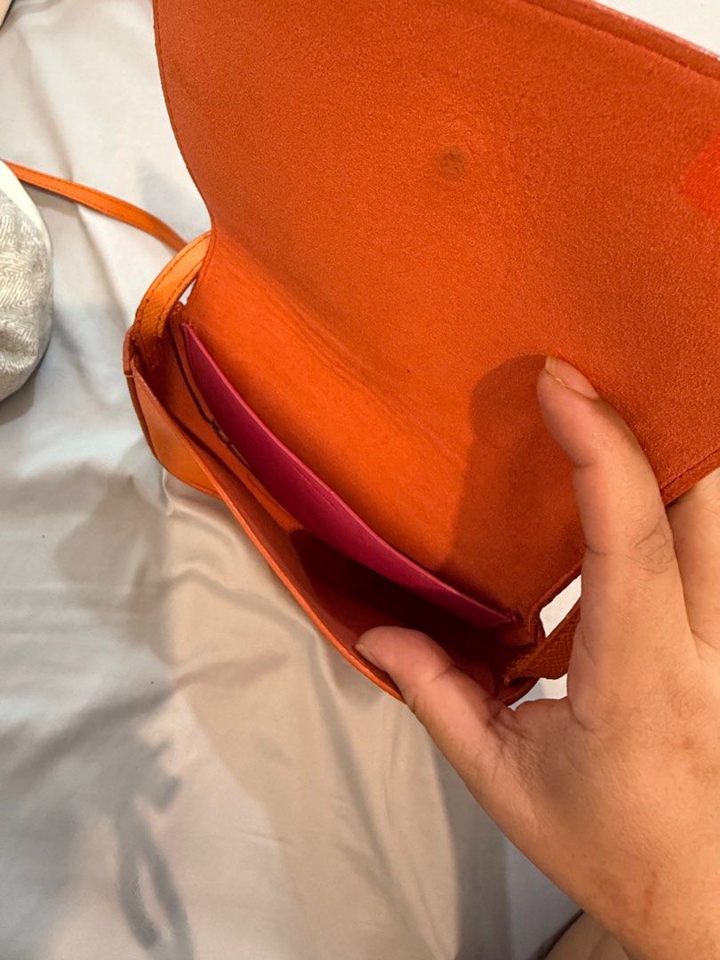 Celine Orange Crossbody Bag (Category: Luxury Bags & Wallets) located in Marikina City. Submitted by robicamz (Listing ID 1402517104, Image 3). Description: Authentic Orange crossbody bag with a pink strap. (Very cutesy) Features the Celine Paris logo and "Made in Italy" inscription. The bag has a flap closure and a long strap. The pink strap shows some wear and tear (see last photo) Slightly negotiable.