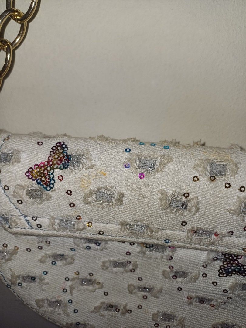 Sparkly Handbag (Category: Luxury Bags & Wallets) located in Quezon City. Submitted by declutterhouse (Listing ID 1402514509, Image 3). Description: - Unique design with embellished exterior - Chain strap - Blue accents - Adorned with sequins and butterfly details - Curved shape - Flap closure - Made of textured fabric.