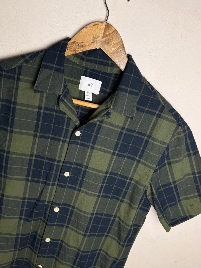 H&M Plaid Short Sleeve Shirt (Category: Formal Shirts) located in Tanza. Submitted by dappydappy (Listing ID 1402576388, Image 2). Description: - H&M short-sleeved shirt - Classic green and navy blue plaid pattern - Collared neckline - Button-down closure - Lightweight fabric, ideal for warm weather - XS 20x25-26 - No flaws Last price posted.