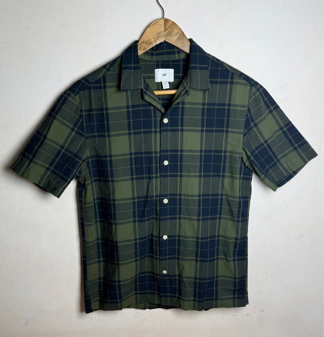H&M Plaid Short Sleeve Shirt (Category: Formal Shirts) located in Tanza. Submitted by dappydappy (Listing ID 1402576388, Image 1). Description: - H&M short-sleeved shirt - Classic green and navy blue plaid pattern - Collared neckline - Button-down closure - Lightweight fabric, ideal for warm weather - XS 20x25-26 - No flaws Last price posted.
