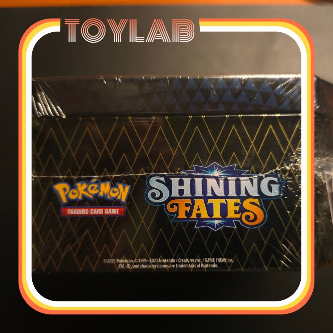 Pokemon Shining Fates Container Tin (Category: Card Boxes & Cases) located in Mandaluyong City. Submitted by ToyLab.ph (Listing ID 1402495972, Image 2). Description: - Sealed Pokemon Shining Fates Tin - Features artwork of a Pokemon - Black tin with gold accents - Empty tin for ypur card storage - Unopened and in original packaging Gcash Payment Lalamove or Grab care of buyer Thank you. 🙂.