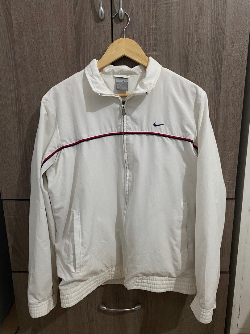 Vintage White Nike Windbreaker (Category: Coats, Jackets and Outerwear) located in Bacoor. Submitted by visualsells (Listing ID 1402506538, Image 2). Description: W23 L27 Fave 🔥 Color rate: 9/10 One hidden pocket on left chest (see img 9) Issues: repaired colar cut, cut small washtag and small hole on the left shoulder. Still in very good condition Negotiable.