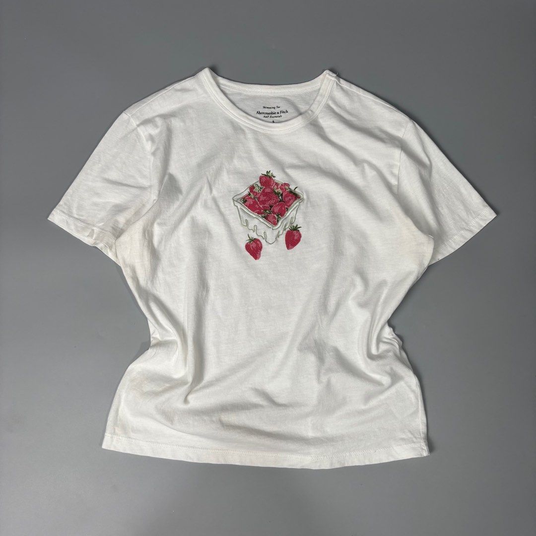 Abercrombie & Fitch Strawberry Graphic Tee (Category: Blouses) located in Angeles City. Submitted by tey68 (Listing ID 1402802036, Image 1). Description: - Abercrombie & Fitch t-shirt - Size: Small - Features a strawberry graphic - Crew neck and short sleeves - Soft and comfortable material - Ideal for everyday wear.