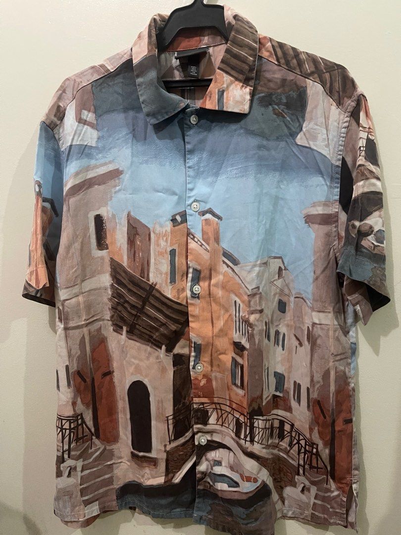 H&M Printed Short Sleeve Shirt (Category: Tshirts & Polo Shirts ) located in Makati City. Submitted by renzzee (Listing ID 1402760482, Image 1). Description: - H&M short sleeve shirt - Unique cityscape print - Button-down front - Classic collar - Lightweight fabric - Relaxed fit - Perfect for casual wear Dimensions: L-26 , W- 20.