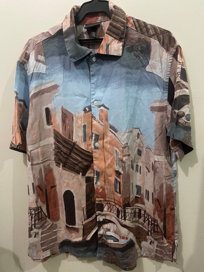 H&M Printed Short Sleeve Shirt (Category: Tshirts & Polo Shirts ) located in Makati City. Submitted by renzzee (Listing ID 1402760482, Image 2). Description: - H&M short sleeve shirt - Unique cityscape print - Button-down front - Classic collar - Lightweight fabric - Relaxed fit - Perfect for casual wear Dimensions: L-26 , W- 20.
