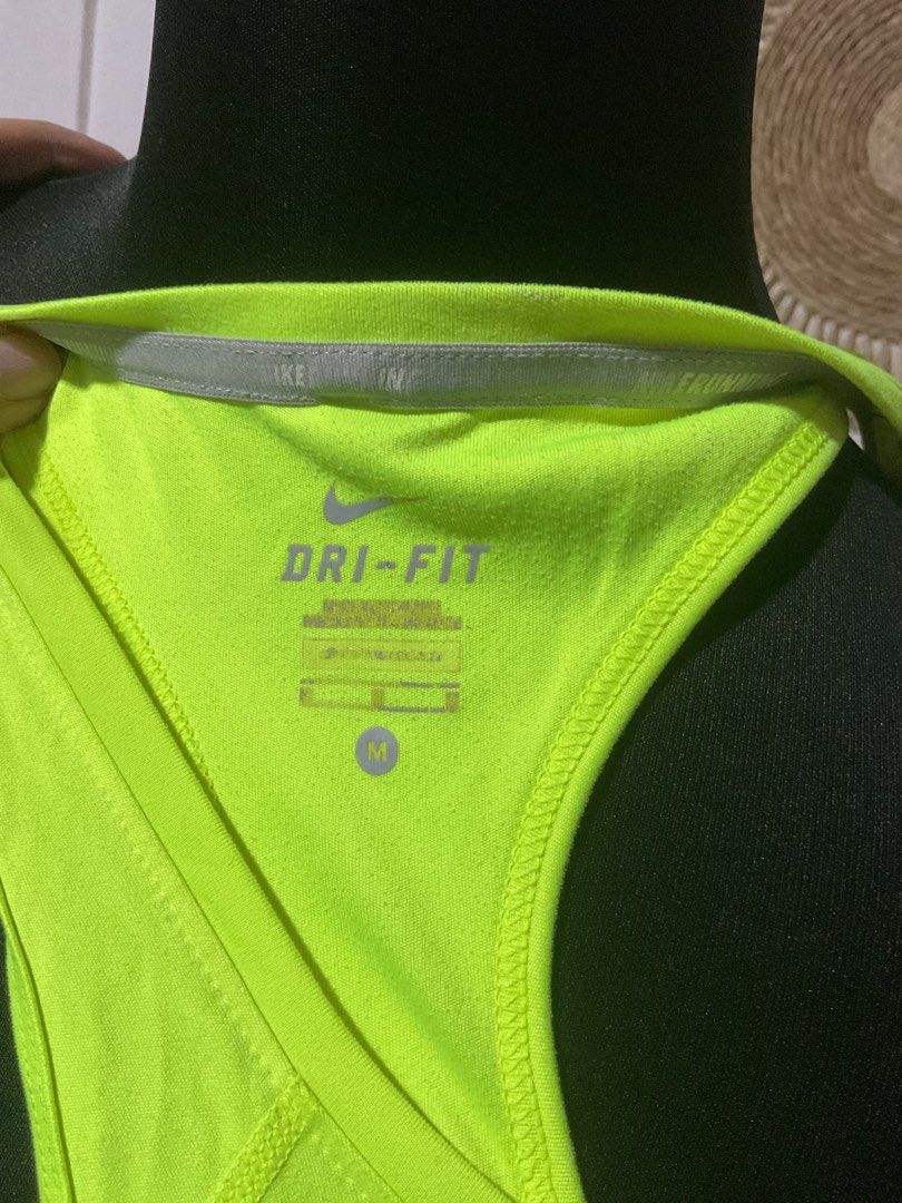Nike Dri-FIT bundle of three (Category: Activewear) located in Manila. Submitted by timelesstouch (Listing ID 1402663435, Image 3). Description: Nike Dri-FIT neon green tank top. Features a small Nike logo on the chest. The tank top is a racerback style with a v-neck. The size is medium. It has a reflective strip on the back. Made with Dri-FIT technology.White shirt in medium size and Nike sleeveless open back.