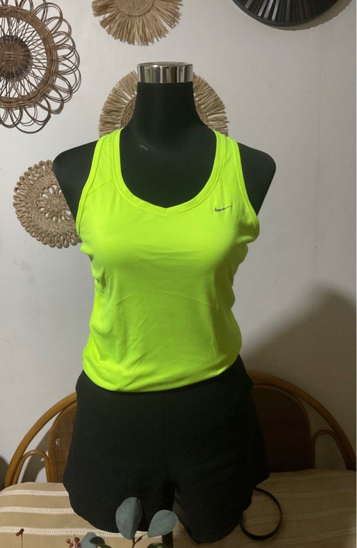 Nike Dri-FIT bundle of three (Category: Activewear) located in Manila. Submitted by timelesstouch (Listing ID 1402663435, Image 2). Description: Nike Dri-FIT neon green tank top. Features a small Nike logo on the chest. The tank top is a racerback style with a v-neck. The size is medium. It has a reflective strip on the back. Made with Dri-FIT technology.White shirt in medium size and Nike sleeveless open back.