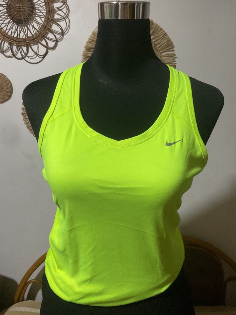 Nike Dri-FIT bundle of three (Category: Activewear) located in Manila. Submitted by timelesstouch (Listing ID 1402663435, Image 1). Description: Nike Dri-FIT neon green tank top. Features a small Nike logo on the chest. The tank top is a racerback style with a v-neck. The size is medium. It has a reflective strip on the back. Made with Dri-FIT technology.White shirt in medium size and Nike sleeveless open back.