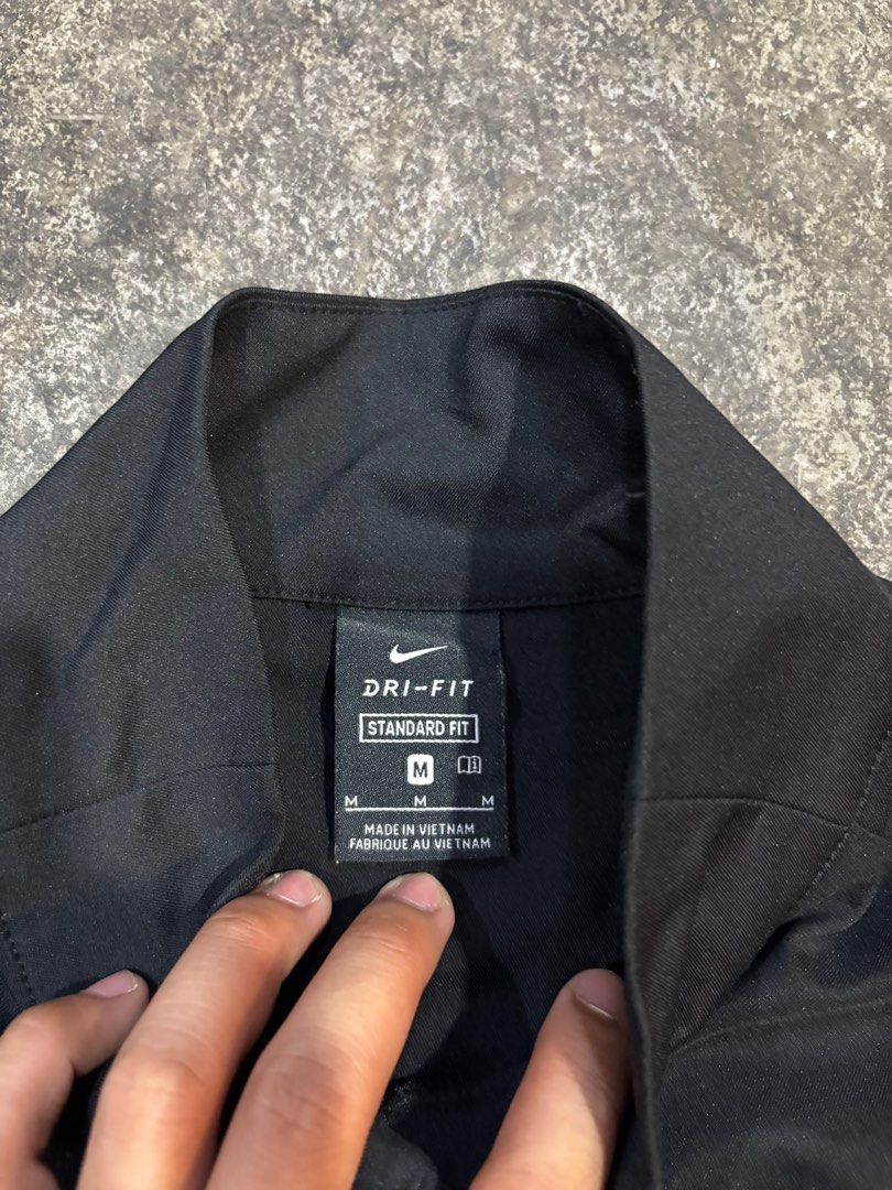 Nike Dri-FIT Standard Fit Jacket - Black (Category: Coats, Jackets and Outerwear) located in General Trias. Submitted by max_thrifted (Listing ID 1402808827, Image 3). Description: - Medium on tag - Weight: 20 - Length: 26 - Exellent condition - No issue - Like new Black Nike Dri-FIT jacket. Features a full-length zipper and the Nike logo on the chest. The jacket is a standard fit and made in Vietnam. The size is M. The jacket has a high collar..