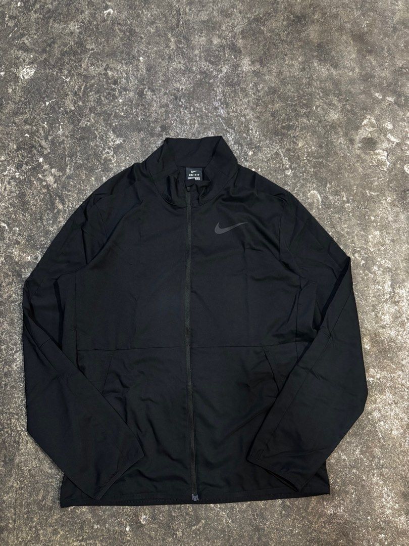 Nike Dri-FIT Standard Fit Jacket - Black (Category: Coats, Jackets and Outerwear) located in General Trias. Submitted by max_thrifted (Listing ID 1402808827, Image 1). Description: - Medium on tag - Weight: 20 - Length: 26 - Exellent condition - No issue - Like new Black Nike Dri-FIT jacket. Features a full-length zipper and the Nike logo on the chest. The jacket is a standard fit and made in Vietnam. The size is M. The jacket has a high collar..