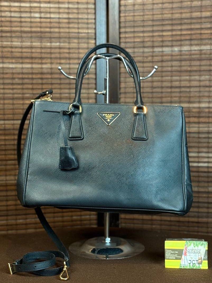 Prada Galleria Saffiano Leather Tote (Category: Luxury Bags & Wallets) located in Baguio. Submitted by BagstacularbyJCT (Listing ID 1402797302, Image 1). Description: This Prada Galleria bag features a Saffiano leather body in black and gold-toned hardware. The Galleria has a distinct sophisticated rectangular silhouette. The interior of the bag consists of a central compartment with the external zippered pockets on either side. The compartments 