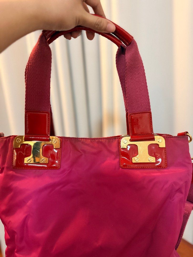 Tory Burch Pink Tote Bag (Category: Luxury Bags & Wallets) located in San Fernando. Submitted by mandts_closet (Listing ID 1402713014, Image 2). Description: - Tory Burch tote bag - Vibrant pink nylon body - Red patent leather accents - Top handle and detachable shoulder strap - Gold-tone hardware - Signature Tory Burch logo - Patterned interior lining - Zippered pocket Sold as is. No refunds. RFS: decluttering For shipping only..