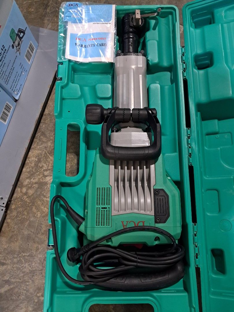 DCA Demolition Hammer (Category: Construction Tools & Equipment) located in Makati City. Submitted by mandiajan62104 (Listing ID 1402857818, Image 1). Description: - DCA demolition hammer - Original green case - Color: Green and black - Includes accessories - Black power cord - Black and gray handle.