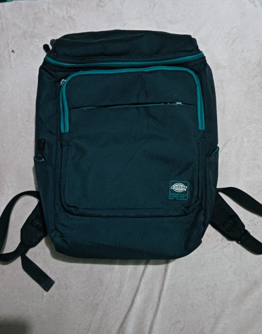 Dickies Backpack (Category: Backpacks) located in Laoag. Submitted by catrnzjb153008 (Listing ID 1402996191, Image 1). Description: - Dickies backpack - Multiple compartments - Laptop sleeve - Padded shoulder straps - Top handle - Dickies logo detail - Teal zipper accents.