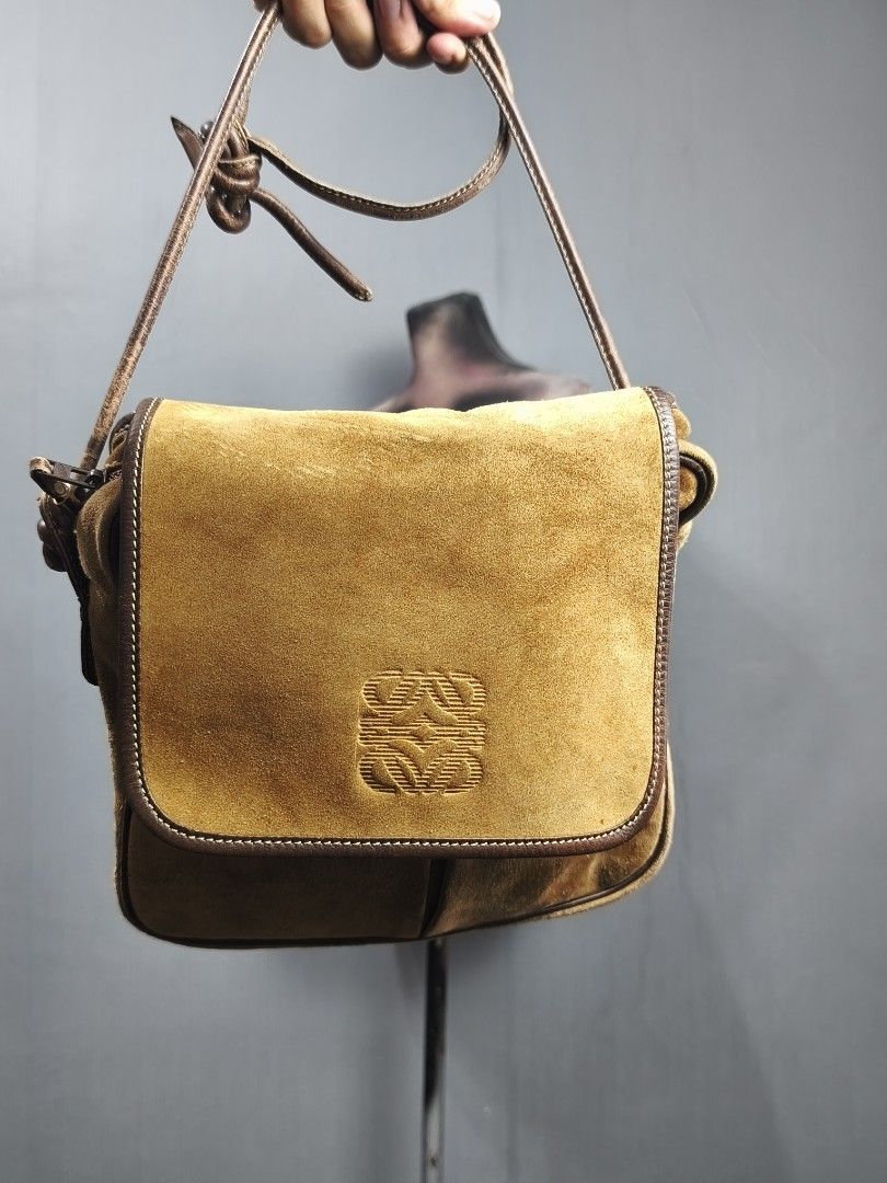 Loewe Suede Shoulder Bag (Category: Luxury Bags & Wallets) located in Dasmarinas. Submitted by goldengem_e4eb01 (Listing ID 1402899360, Image 1). Description: - Authentic Loewe shoulder bag - Suede exterior with leather trim - Flap closure with embossed Loewe logo - Gold-tone lock with Loewe logo - Zippered main compartment - Interior pocket - Includes shoulder strap.