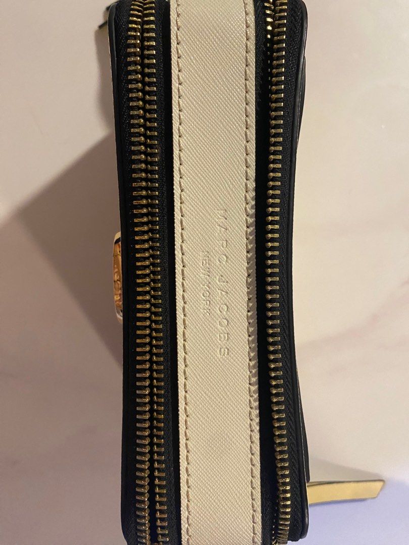 Marc Jacobs The Snapshot Crossbody Bag (Category: Luxury Bags & Wallets) located in Quezon City. Submitted by harleys_stuff (Listing ID 1403011368, Image 3). Description: Marc Jacobs Snapshot crossbody bag features a pale yellow body with a gold-tone logo and hardware. It includes a detachable, striped shoulder strap / guitar strap with gold clasps. The bag has a zip closure. The interior is black. The brand name is visible on the zipper pull and
