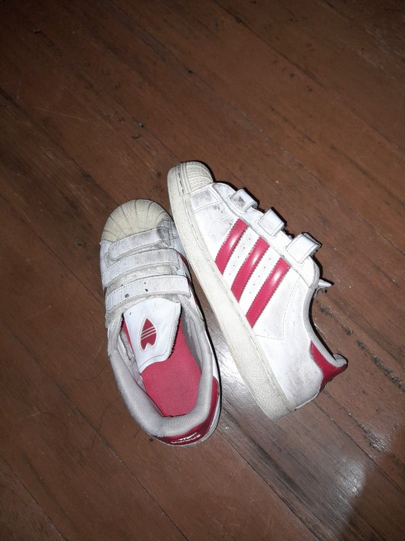 Adidas Superstar Toddler Shoes (Category: Babies & Kids Fashion) located in Marikina City. Submitted by pokemonmimikyu (Listing ID 1403068352, Image 2). Description: - Adidas Superstar toddler shoes - White with red accents - Velcro straps for easy wear - Features heart design on insole - Size: US 2.5 - Stock sa shoerack, ourgrown - Needs cleaning.