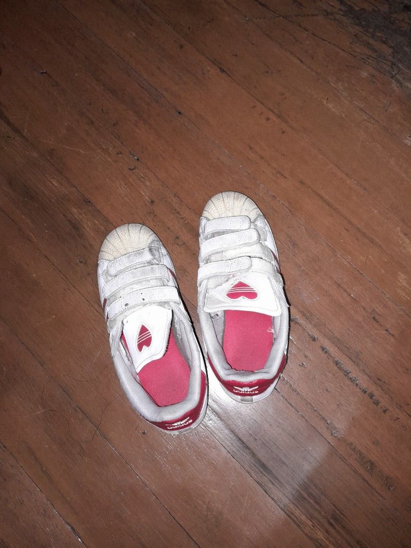 Adidas Superstar Toddler Shoes (Category: Babies & Kids Fashion) located in Marikina City. Submitted by pokemonmimikyu (Listing ID 1403068352, Image 1). Description: - Adidas Superstar toddler shoes - White with red accents - Velcro straps for easy wear - Features heart design on insole - Size: US 2.5 - Stock sa shoerack, ourgrown - Needs cleaning.