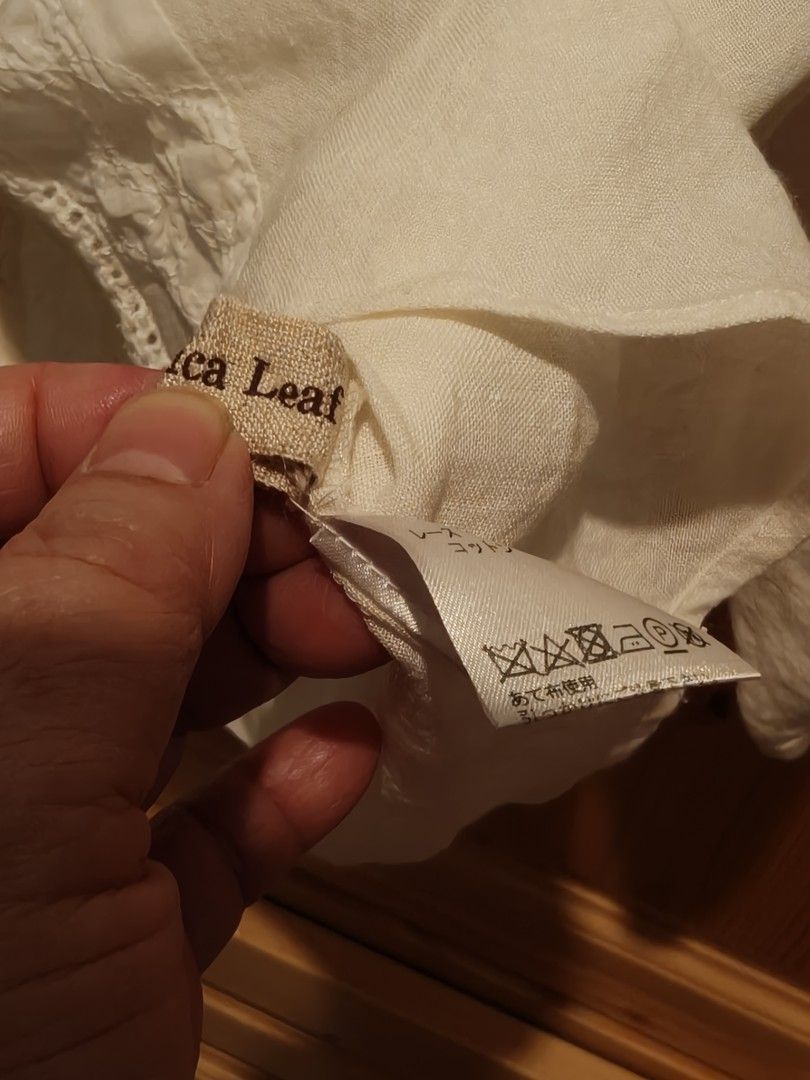 Angelica Leaf 日本製蕾絲上衣 （分類：襯衫）位於 Hong Kong。 由 beautyleun52792 提交（商品編號 1403170043，圖片 6）。簡介： Angelica Leaf蕾絲上衣，日本製。米白色，衣身有蕾絲拼接設計，袖子為七分袖。領口後方有鈕扣。衣長約50cm，胸圍約50cm。衣物上有品牌標籤，並標示了洗滌說明。適合日常穿搭，展現優雅氣質。。