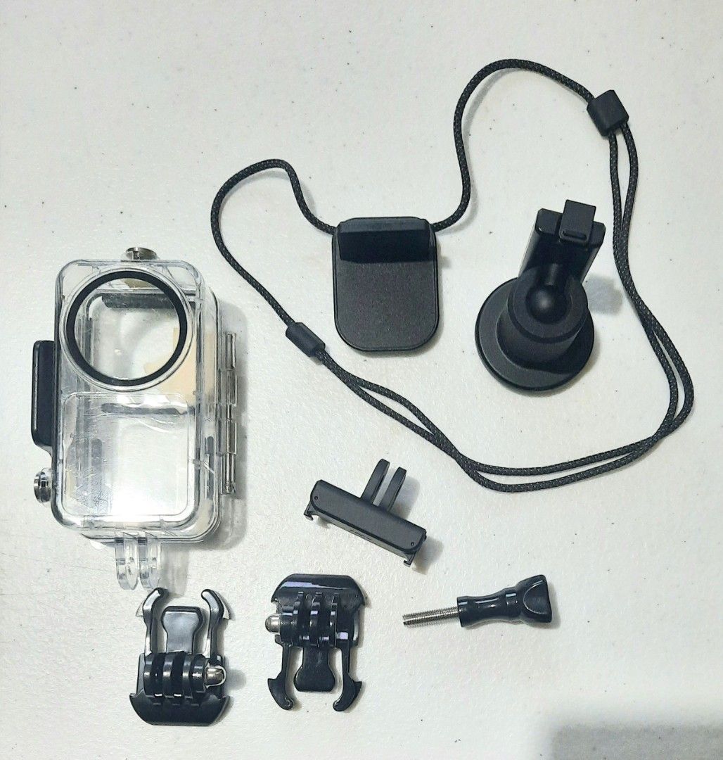 DJI Action 2 Camera Accessories Kit (Category: Cameras) located in Quezon City. Submitted by jenlemuel (Listing ID 1403152875, Image 1). Description: Kit includes an action camera waterproof case, various mounts, and a neck strap. It features a suction mount, a clip mount, and several other mounting accessories. Perfect for capturing underwater shots or securing your camera in various environments. The kit provides versatile options for different
