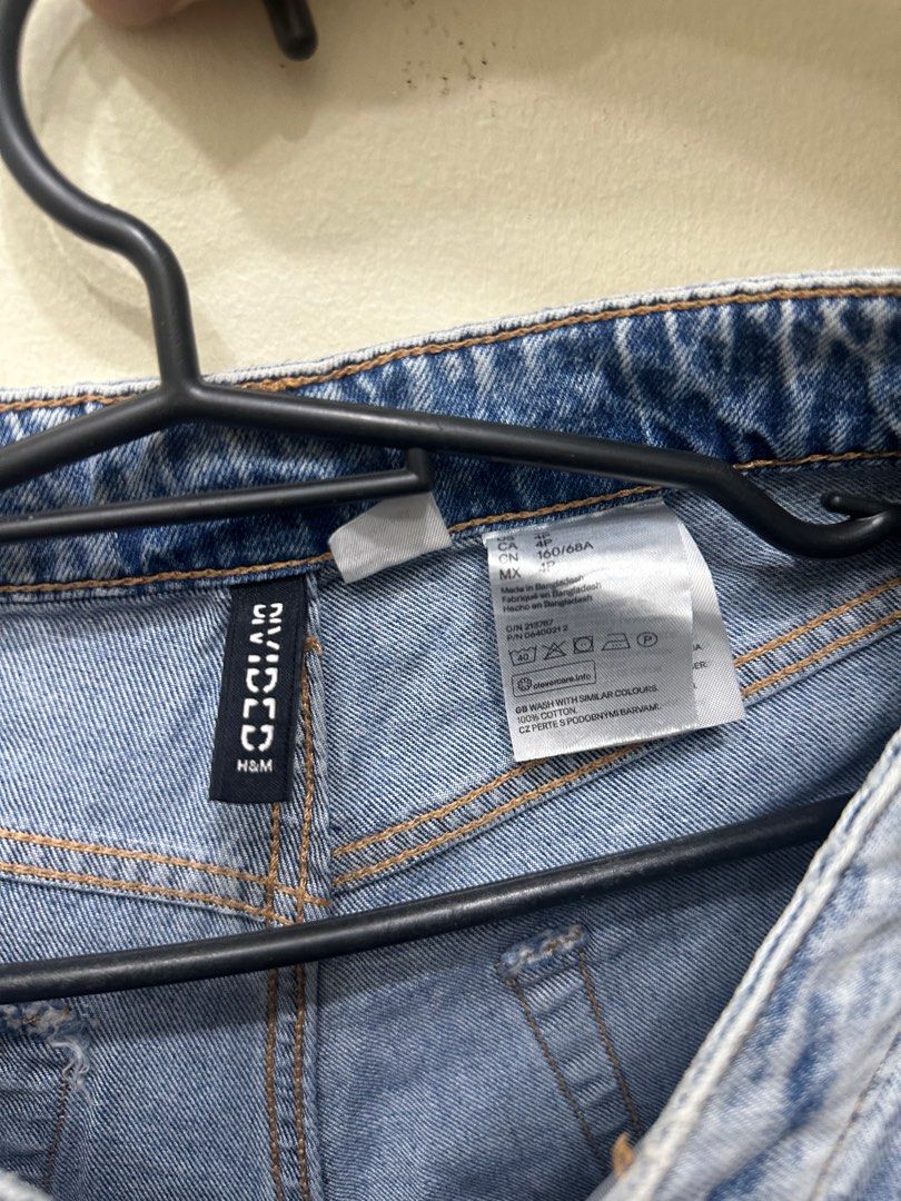 H&M Divided Distressed Jeans (Category: Jeans) located in Manila. Submitted by traderjoe_ (Listing ID 1403188651, Image 2). Description: Light blue distressed jeans from H&M Divided. Features a button closure and multiple rips. The size is indicated as 27/68A. The jeans have a light wash and a straight leg fit. The jeans have a raw hem. Made of cotton..