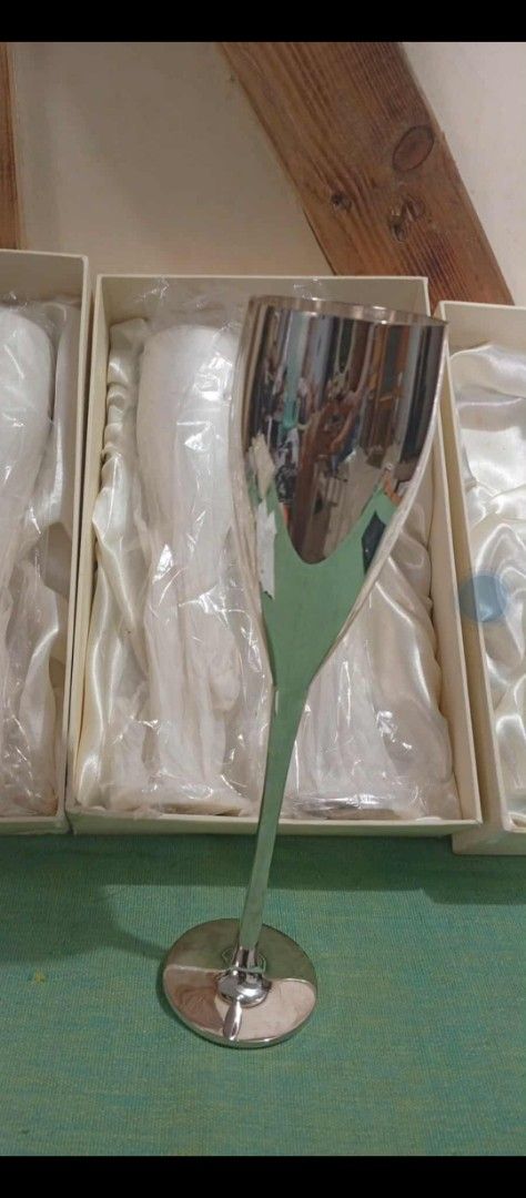 Silver Champagne Flutes Set (Category: Coffee & Tea Tableware) located in Calamba. Submitted by cecilmarcyfaith (Listing ID 1403046869, Image 1). Description: Elegant set of silver champagne flutes. Each flute is presented in its own box, suggesting careful storage. The flutes have a sleek, modern design with a long stem and a wide bowl. Perfect for special occasions or adding a touch of sophistication to your home bar..