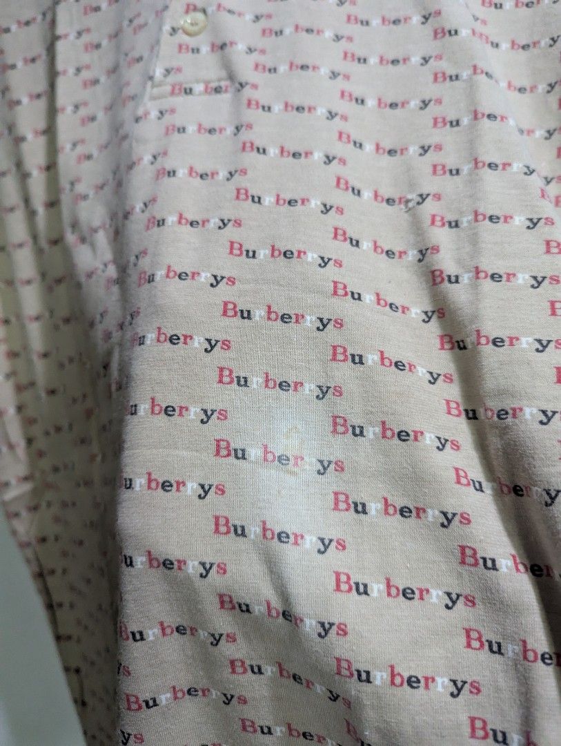 Vintage Burberry Polo shirt (Category: Tshirts & Polo Shirts ) located in Quezon City. Submitted by lancelooot (Listing ID 1403181096, Image 2). Description: - Authentic Burberrys polo shirt - Beige color with all-over brand name print - Classic polo collar - Button-up placket - Size: M - may stain on lower left.