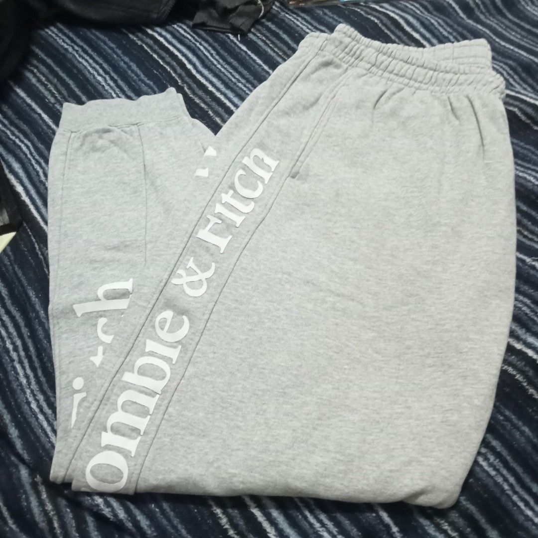 Abercrombie & Fitch XL Sweatpants (Category: Coats, Jackets and Outerwear) located in Bulacan. Submitted by fujikko (Listing ID 1407194635, Image 1). Description: Gray Abercrombie & Fitch sweatpants. Features the brand name printed vertically on the side of the leg. Includes a back pocket and an elastic waistband. Size XL. Made in China. Care instructions include gentle machine wash at 30°C, do not bleach, cool iron, do not dry clean, do not tumb