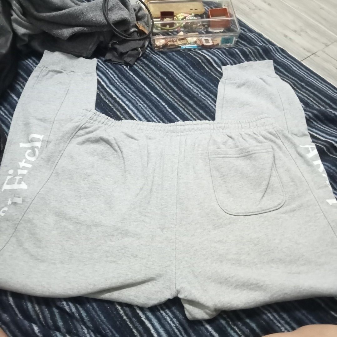 Abercrombie & Fitch XL Sweatpants (Category: Coats, Jackets and Outerwear) located in Bulacan. Submitted by fujikko (Listing ID 1407194635, Image 3). Description: Gray Abercrombie & Fitch sweatpants. Features the brand name printed vertically on the side of the leg. Includes a back pocket and an elastic waistband. Size XL. Made in China. Care instructions include gentle machine wash at 30°C, do not bleach, cool iron, do not dry clean, do not tumb