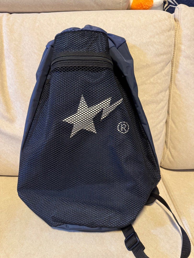 BAPE Drawstring Backpack （分類：背包）位於 Hong Kong。 由 shopaholic_2010 提交（商品編號 1407285835，圖片 1）。簡介： Navy blue drawstring backpack with a mesh front panel. Features a zippered pocket and adjustable straps. The BAPE logo is prominently displayed on the front. Includes a small tag with the BAPE logo at the bottom. The bag has a drawstring closure at the top and a small pocket inside.。